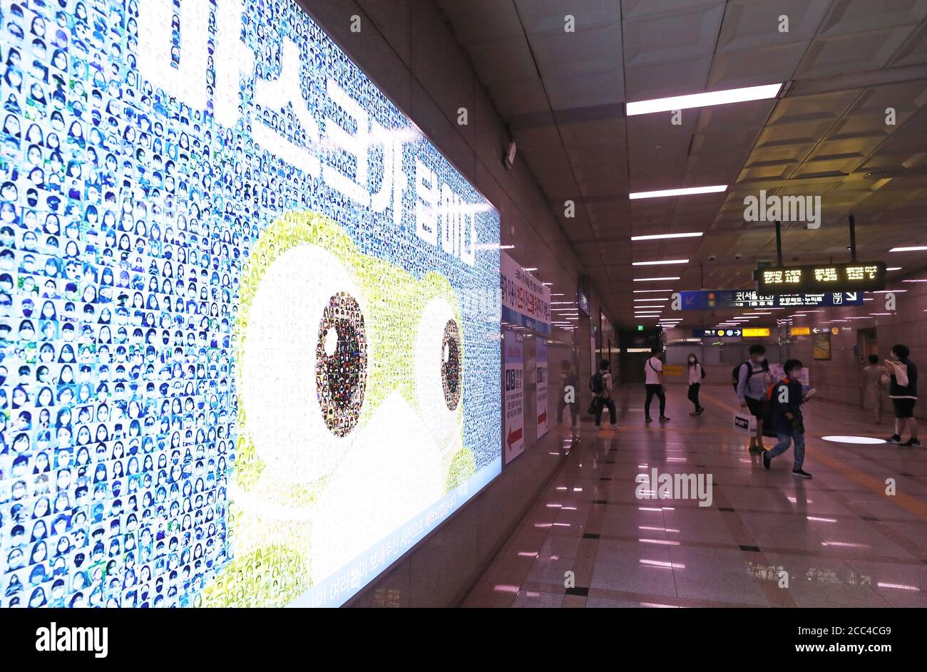 Bürger des neuen Coronavirus kommen am 18. August 2020 an einer Station in Suwon, südlich von Seoul, an einer Tafel vorbei, auf der Fotos von maskierten Menschen und eine Botschaft auf Koreanisch mit der Aufschrift "EINE Maske ist die Antwort (auf das neue Coronavirus)" zu sehen sind. Die Regierung hob die Richtlinien zur sozialen Distanzierung in Seoul und der umliegenden Provinz Gyeonggi nach einem Anstieg der neuen Coronavirus-Infektionen in den Regionen an. (Yonhap)/2020-08-18 16:19:08/ Foto via Newscom Stockfoto