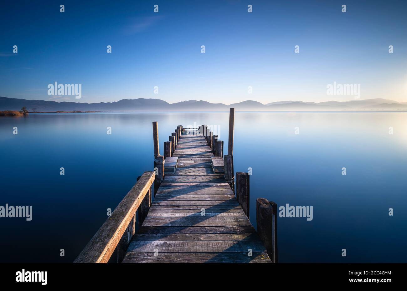 Holzsteg oder Steg und See bei Sonnenaufgang. Torre del Lago Puccini, Versilia, Massaciuccoli See, Toskana, Italien, Europa Stockfoto