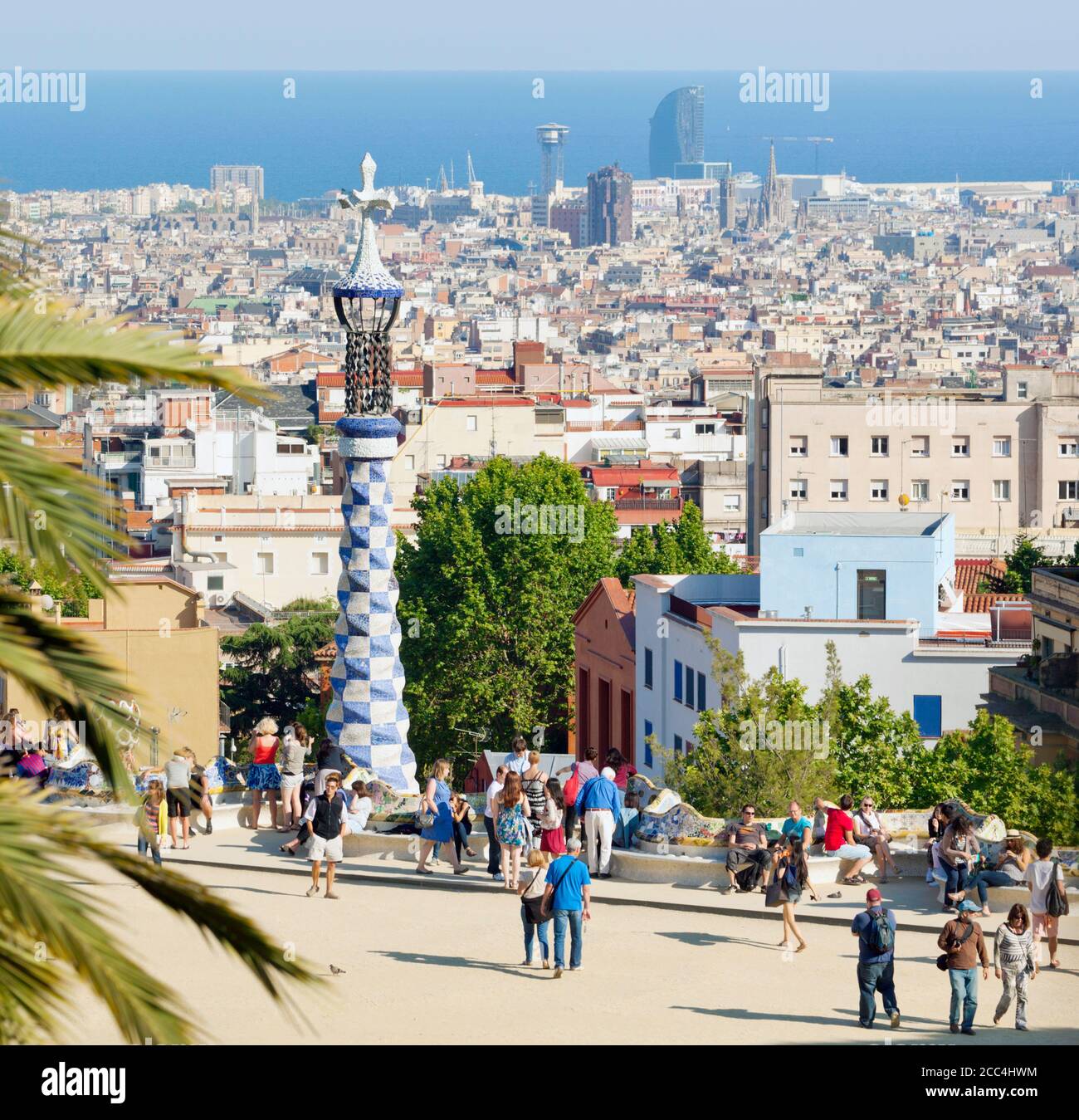 Barcelona, Spanien.  Parc Güell.  Gran Plaça Rundschreiben.  Central Plaza.  Barcelona-Stadtansicht im Hintergrund.  Park Güell wurde von Antoni Gaudi entworfen. Stockfoto