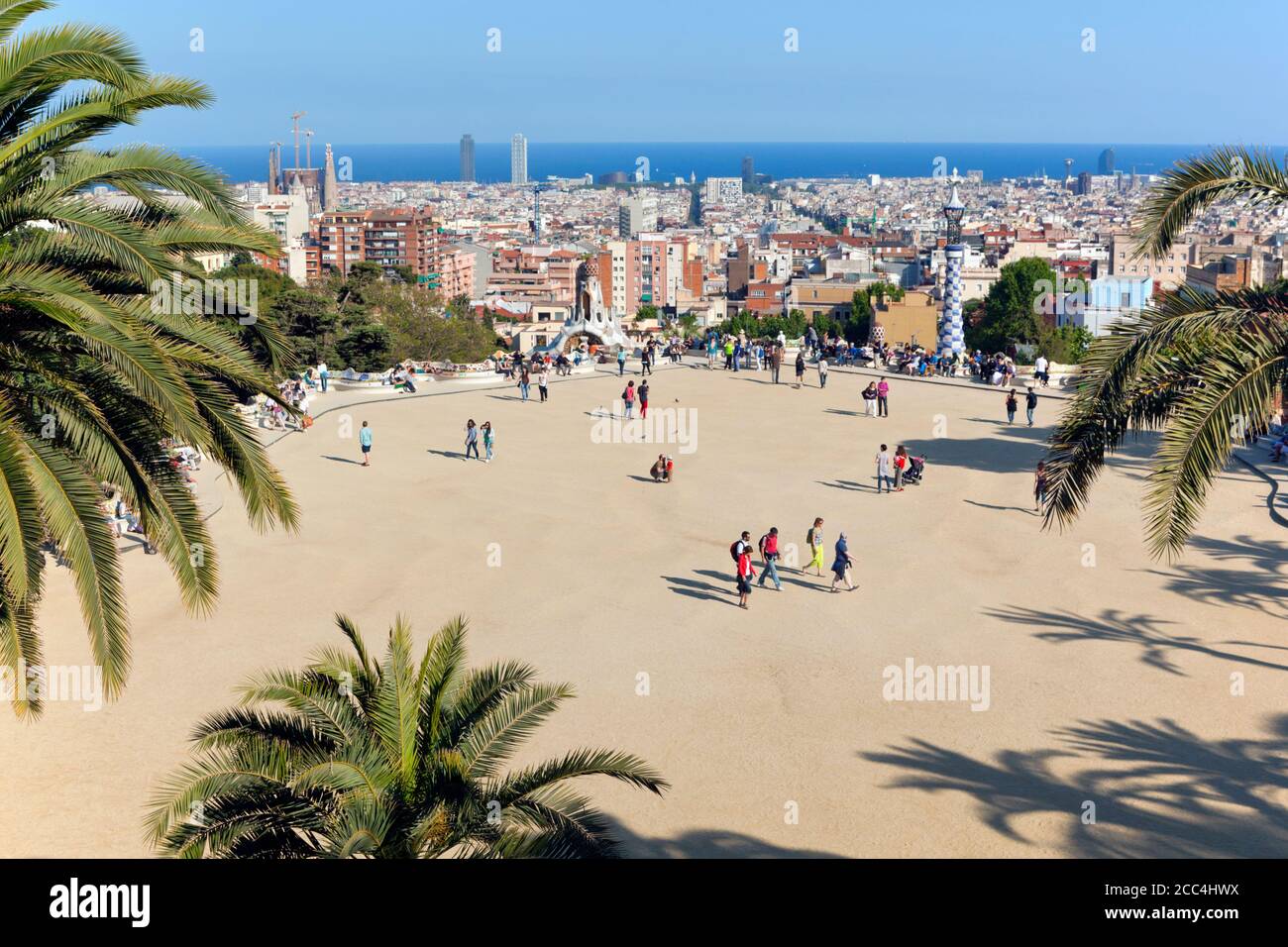 Barcelona, Spanien.  Parc Güell.  Gran Plaça Rundschreiben.  Central Plaza.  Barcelona-Stadtansicht im Hintergrund.  Park Güell wurde von Antoni Gaudi entworfen. Stockfoto