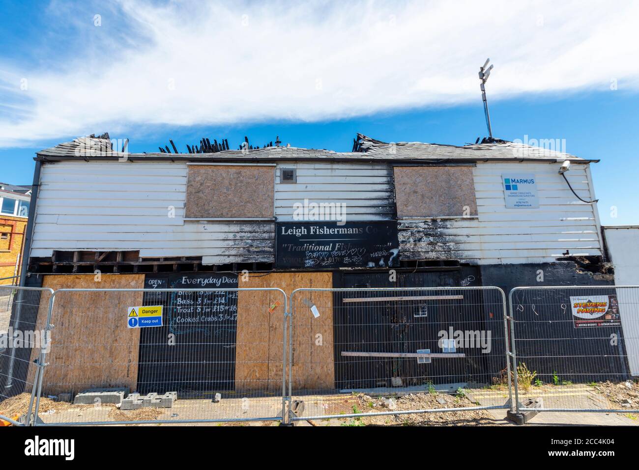 Ausgebrannte Schale der Leigh Fisherman's Co-operative in Leigh on Sea, Essex, Großbritannien. Brandstiftung beschädigte historisches Gebäude mit vertauften Türen. Eingezäunt Stockfoto