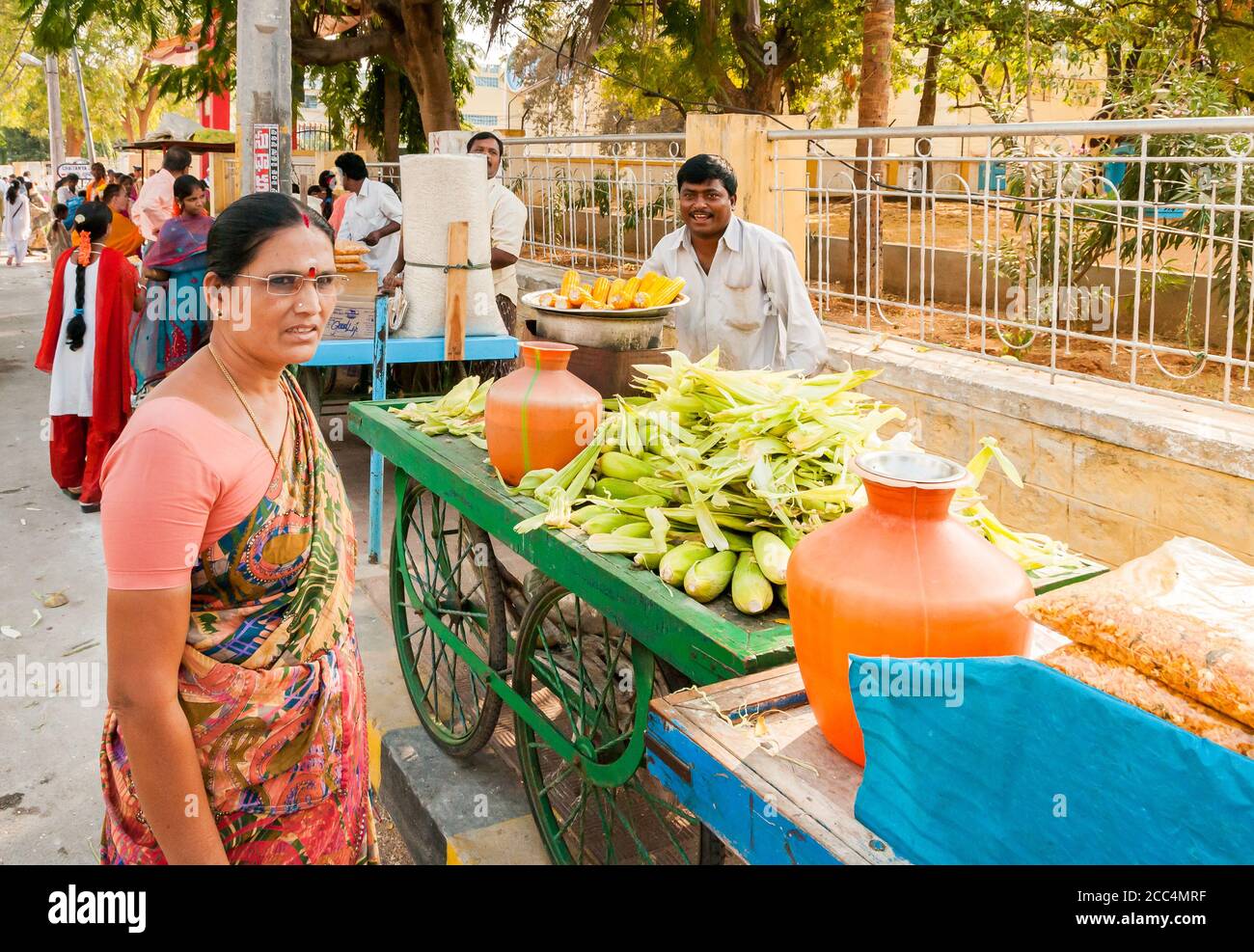 Puttaparthi, Andhra Pradesh, Indien - 13. Januar 2013: Street Food Verkäufer verkaufen Mais in der Straße von Puttaparthi. Stockfoto