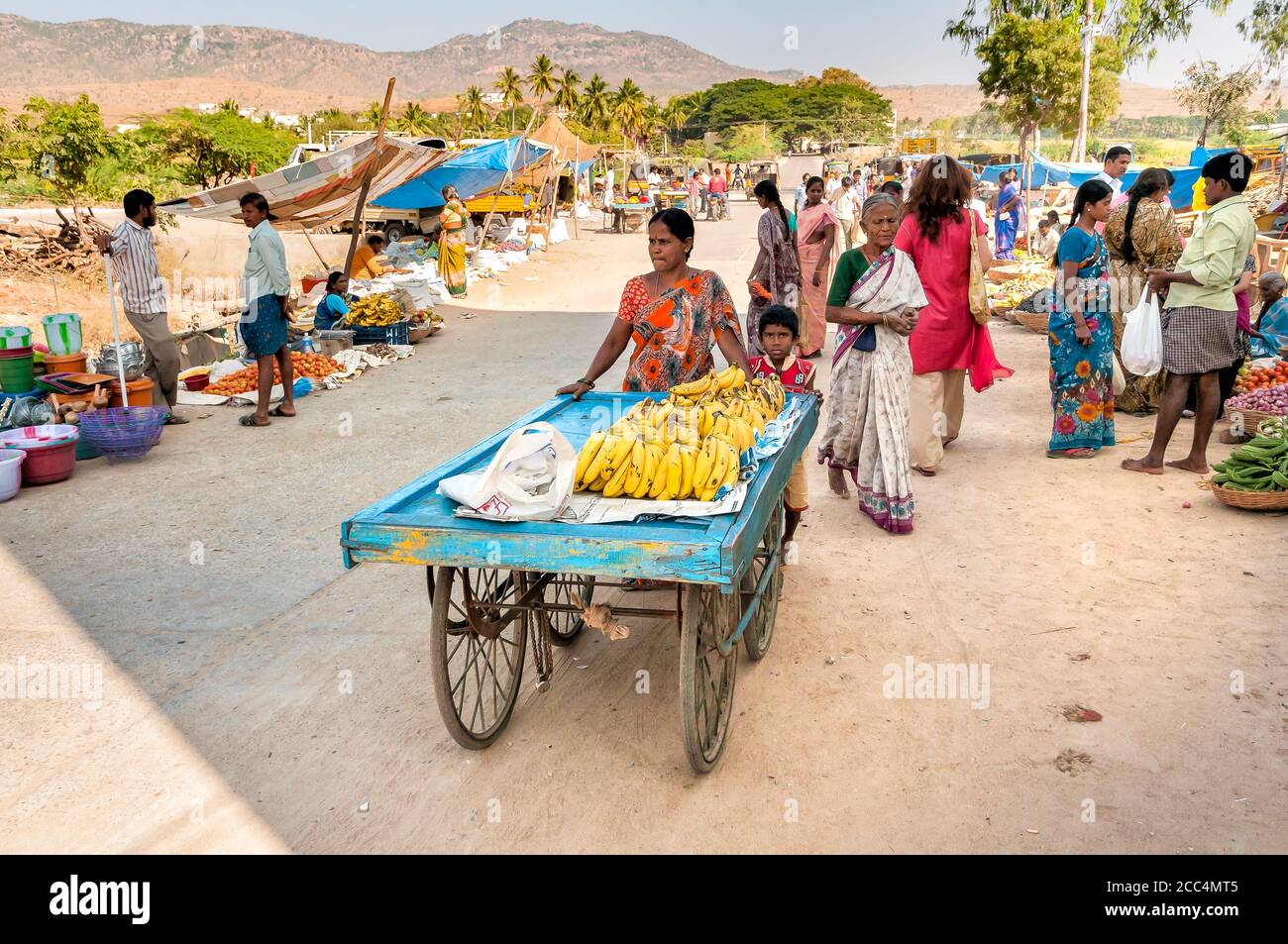Puttaparthi, Andhra Pradesh, Indien - 13. Januar 2013: Mutter und Sohn verkaufen Bananen auf dem Straßenmarkt von Puttaparthi. Stockfoto
