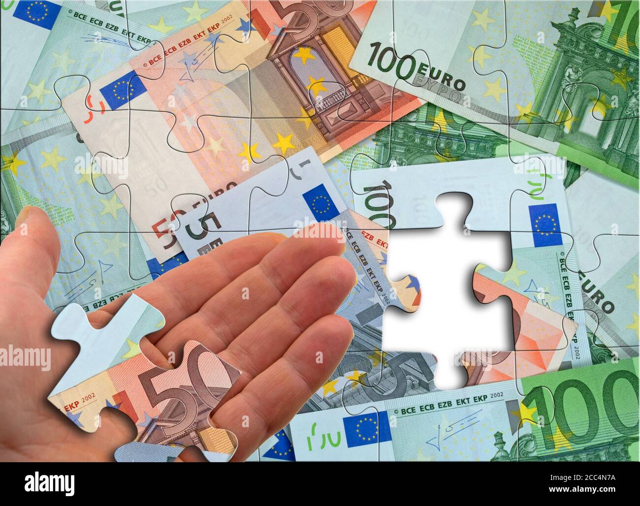 Finanzplanung, symbolische Darstellung, Hand mit Stück Geld Puzzle Stockfoto
