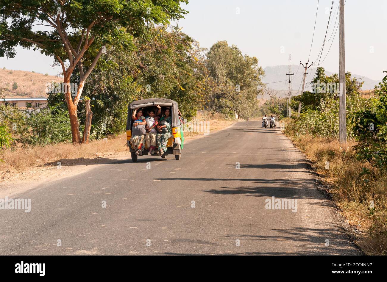 Puttaparthi, Andhra Pradesh, Indien - 12. Januar 2013: Indische Frauen reisen in Rikscha-Taxi entlang der Straße des Dorfes Puttaparthi, Indien Stockfoto