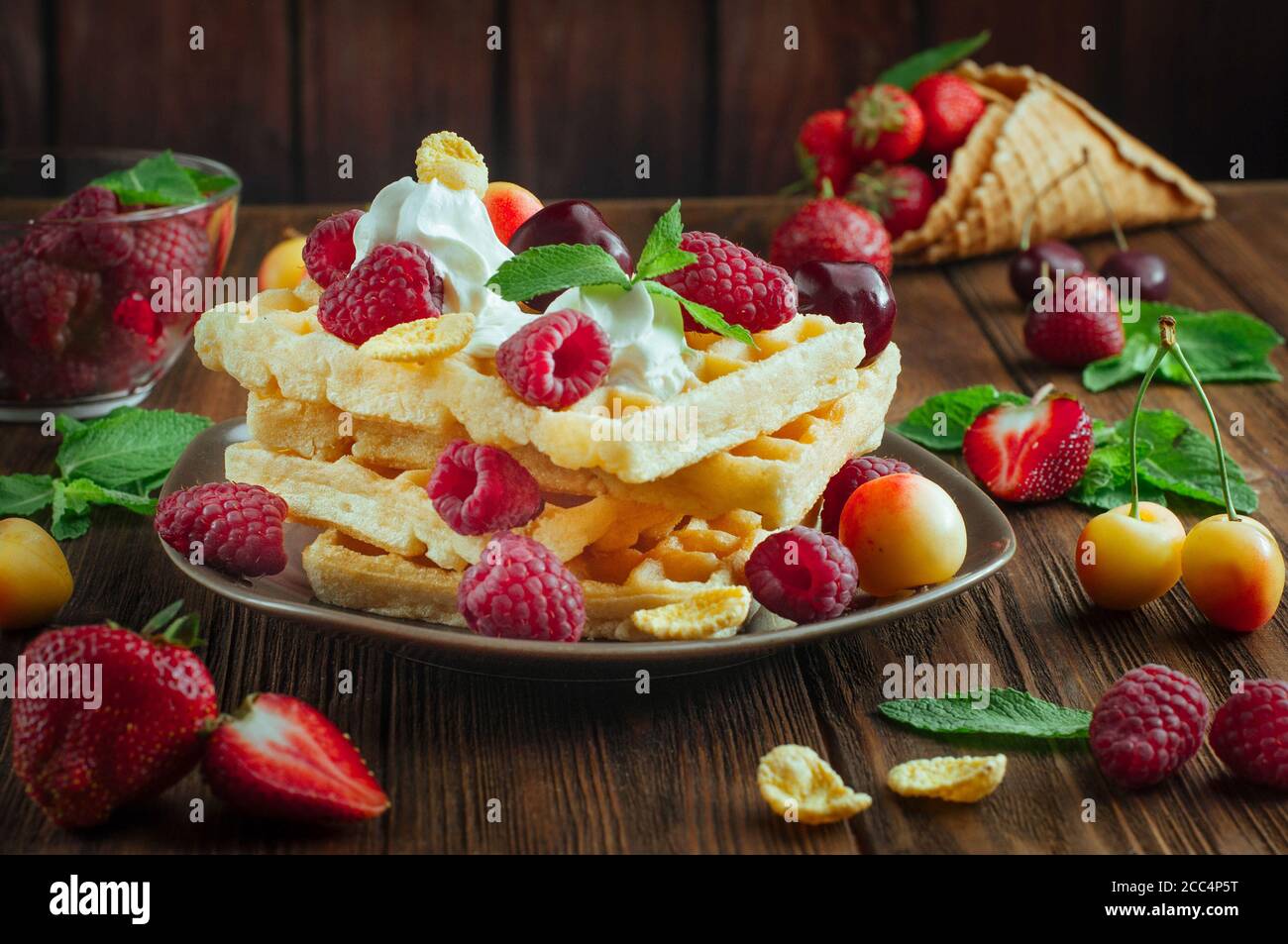 Belgische Waffeln mit Beeren, Schlagsahne und geriebener Schokolade Stockfoto