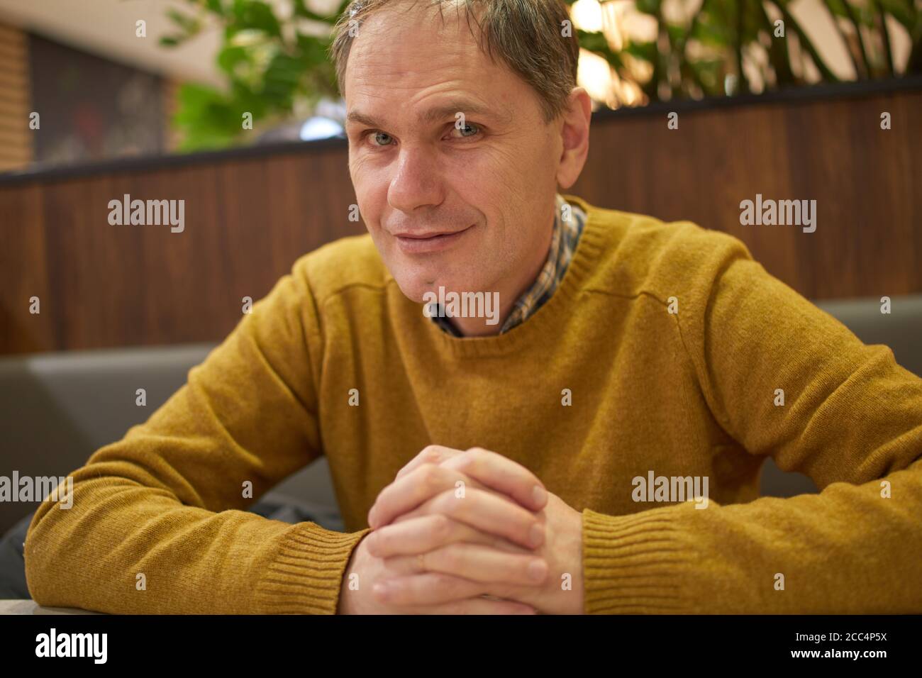 Reifer kaukasischer Mann, der in einem Café sitzt Stockfoto