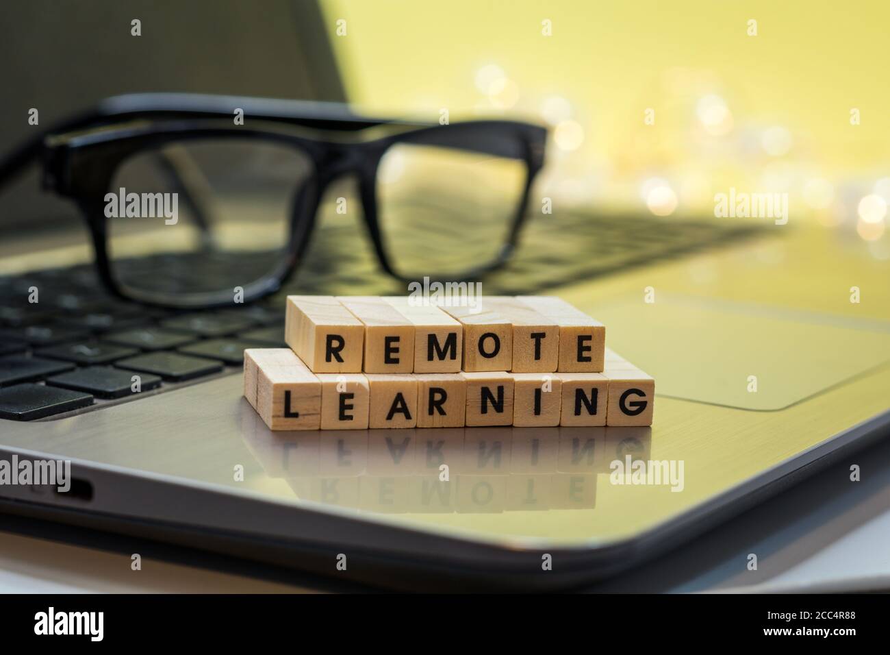 REMOTE LEARNING virtuelles Lernkonzept mit Holzblock Buchstaben auf Laptop. Fernstudium, Fernstudium, virtuelles Lernen. Stockfoto