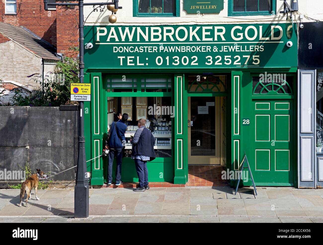 Zwei Männer Schaufensterbummel im Pawnbroker Gold Shop, Market Place, Doncaster, South Yorkshire, England Großbritannien Stockfoto