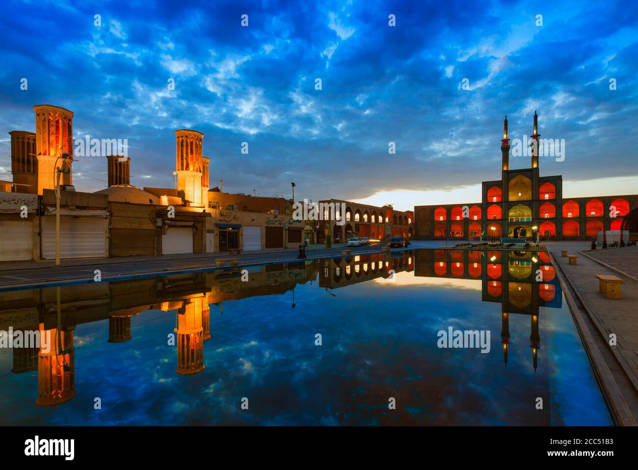Amir Chaqmaq komplexe Fassade bei Sonnenaufgang beleuchtet und in einem Teich, Yzad, Provinz Yazd, Iran reflektiert Stockfoto