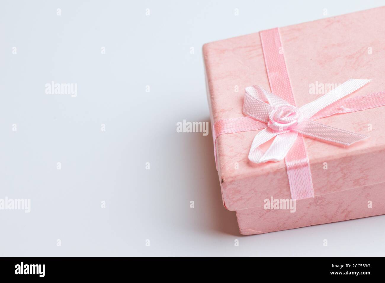 Rosa Box mit Geschenk auf weißem Hintergrund. Speicherplatz kopieren Stockfoto