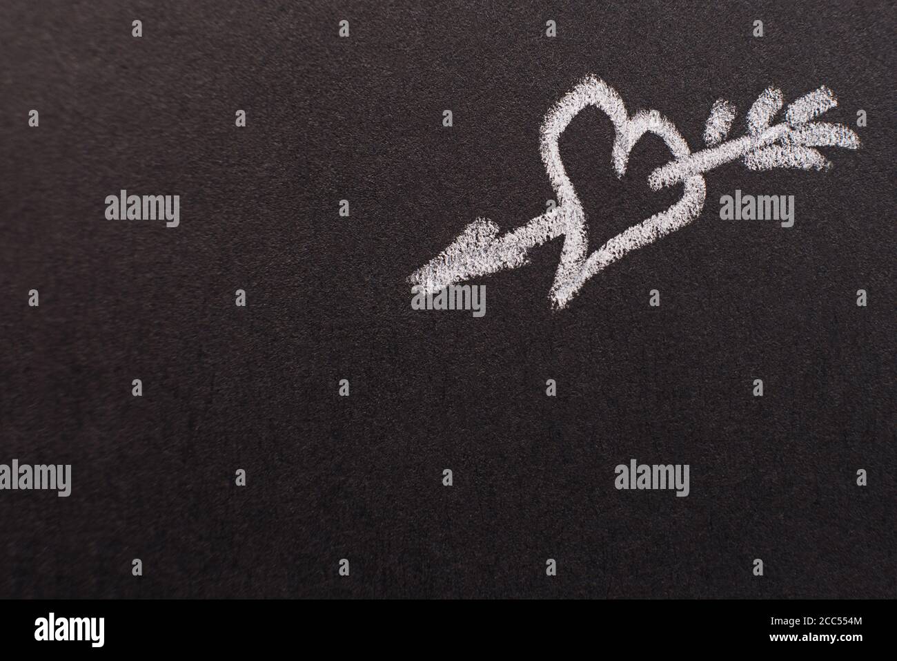 Handgezeichnetes Herz mit Pfeil auf schwarzem Kreidetafel. Kopierraum. valentinstag, alle Liebhaber Konzept Stockfoto