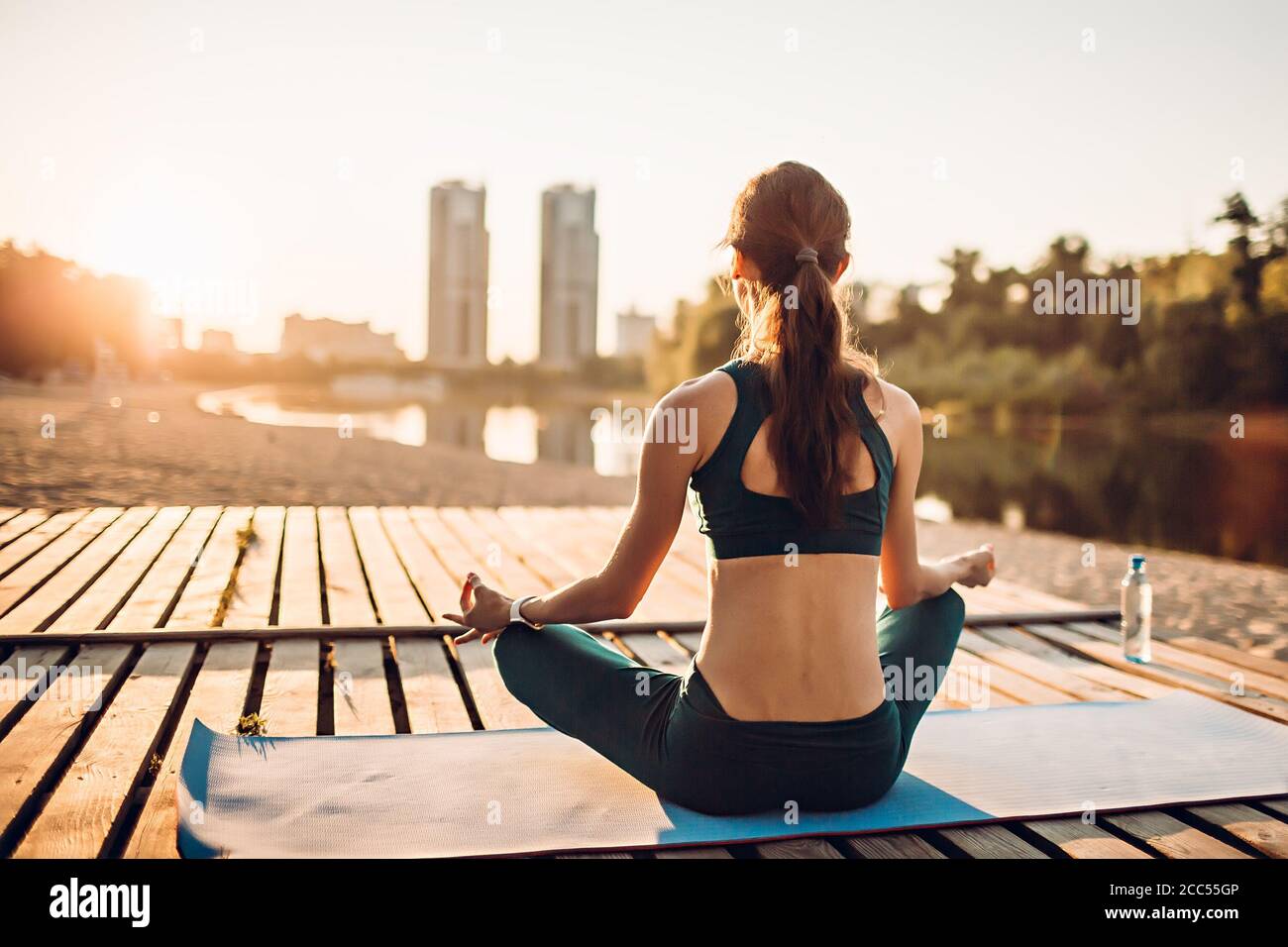Sportlerin meditiert bei Sonnenaufgang Stockfoto