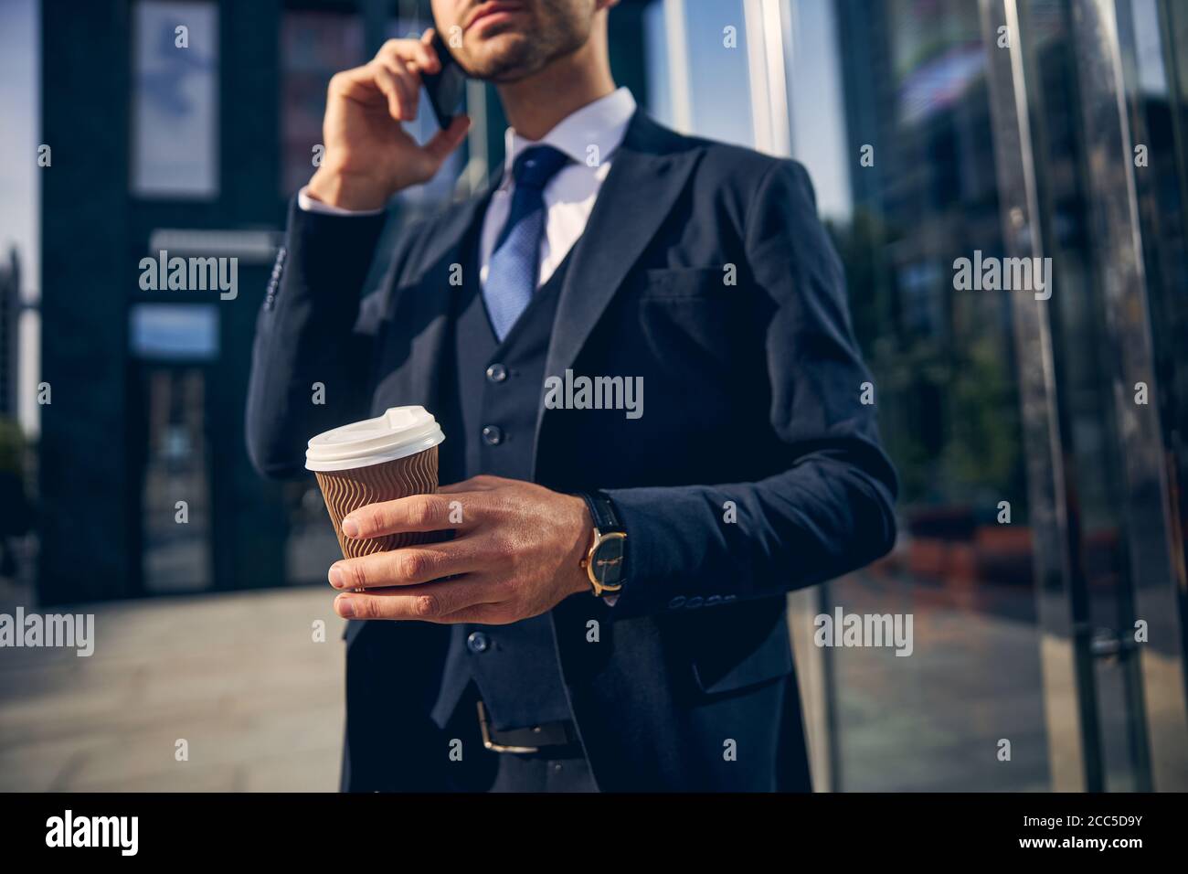 Junger Mann, der vor dem Büro telefoniert Stockfoto