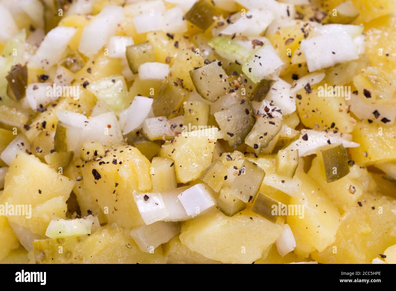 Deutscher Kartoffelsalat mit Zwiebel und Gurke auf Teller Nahaufnahme Selektiver Fokus Stockfoto