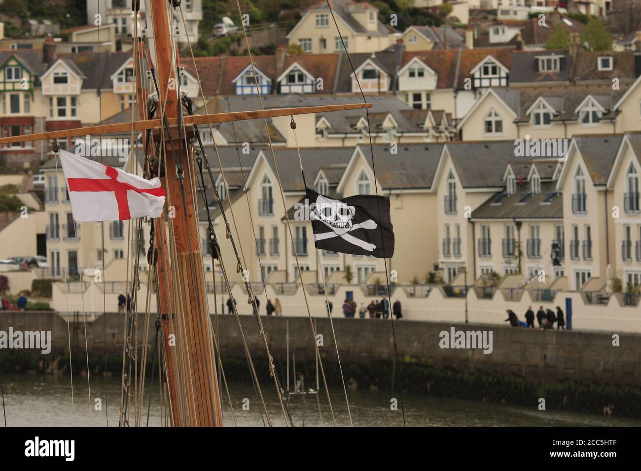 Flagge von St. George und Jolly Roger, die von Holzkreuzbalken des Holzbootes fliegen, Brixham, Devon, UK Stockfoto