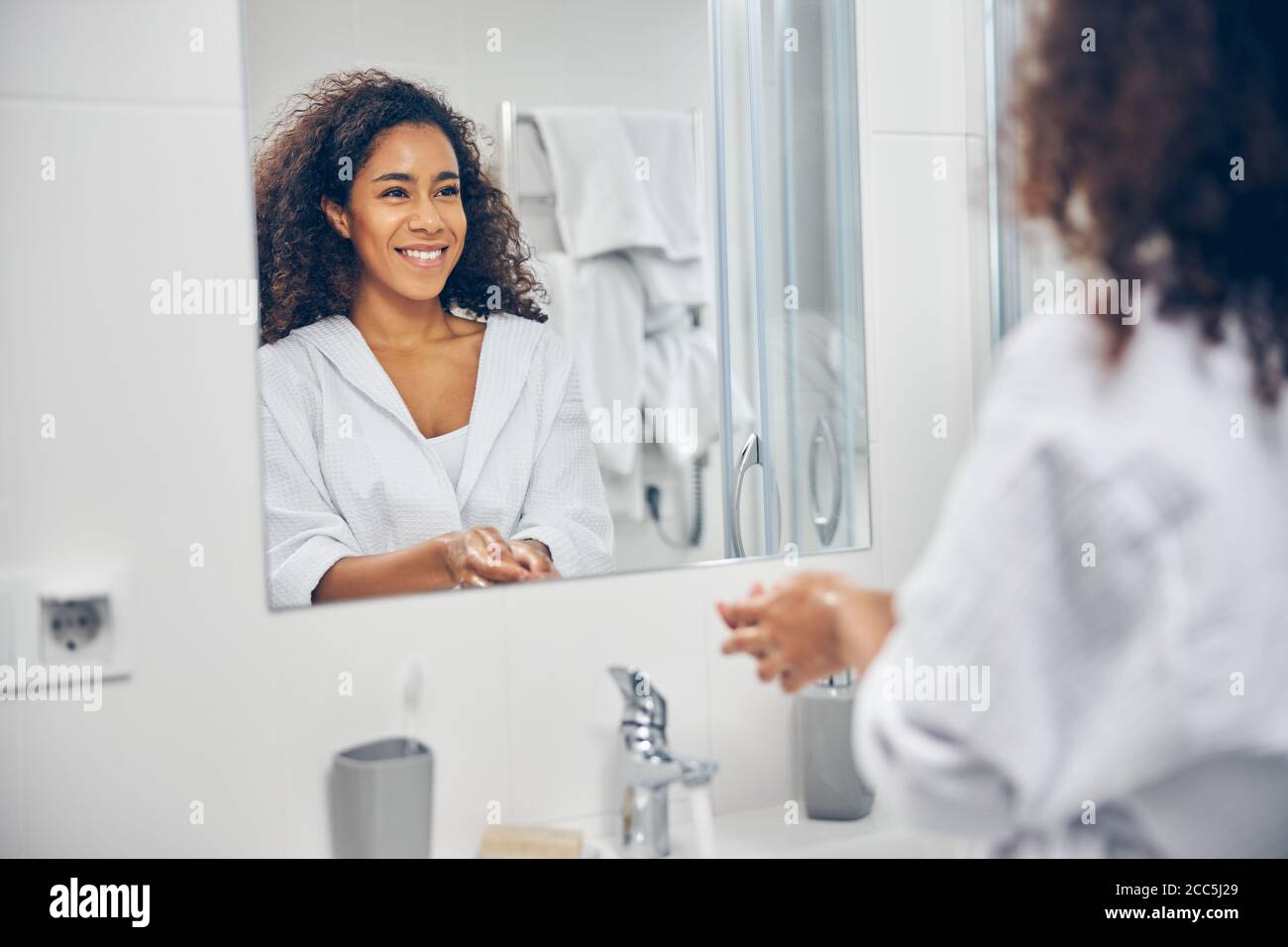 Frau mit einem glücklichen Lächeln im Badezimmer stehen Stockfoto