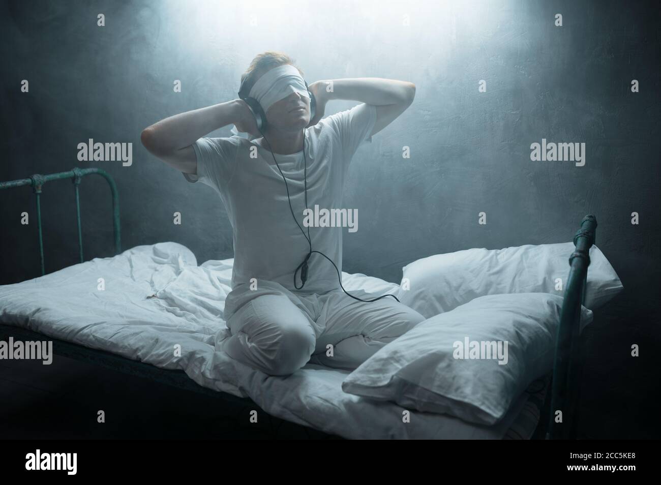 Psycho Mann mit verbundenen Augen im Bett sitzen, Krankenhaus Stockfoto