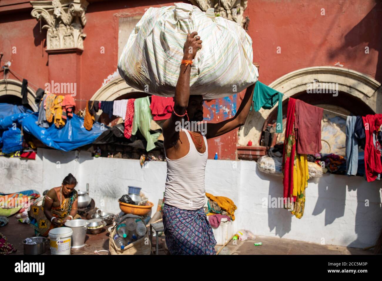 Ein Portier bewegt eine Ladung Waren durch einen Markt in Kalkutta, Indien. Stockfoto