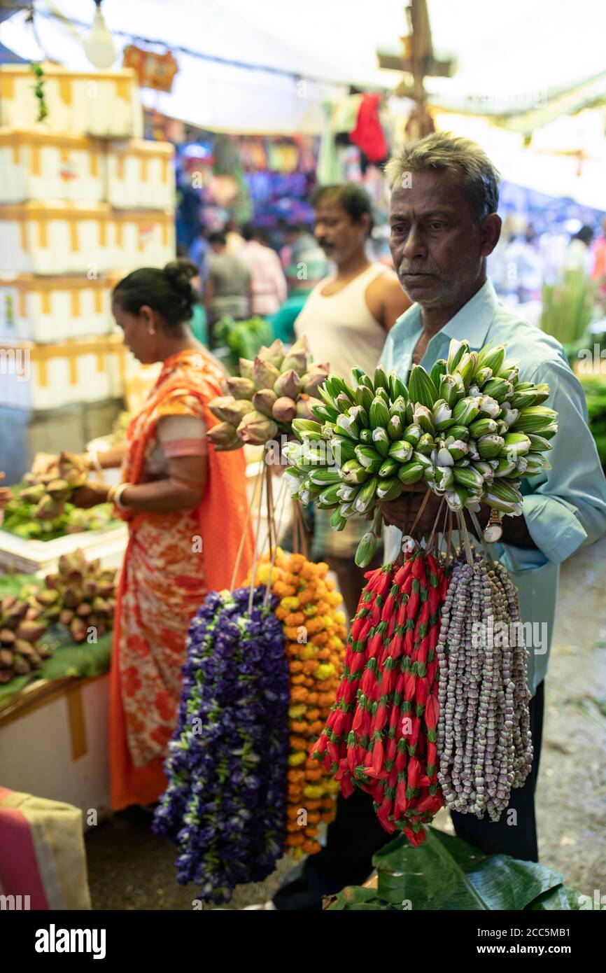 Verkäufer kaufen und verkaufen wunderschöne Girlanden aus Ringelblumen und Lotusblumen auf dem Mullick Ghat Blumenmarkt in Kalkutta, Indien, Südostasien. Stockfoto