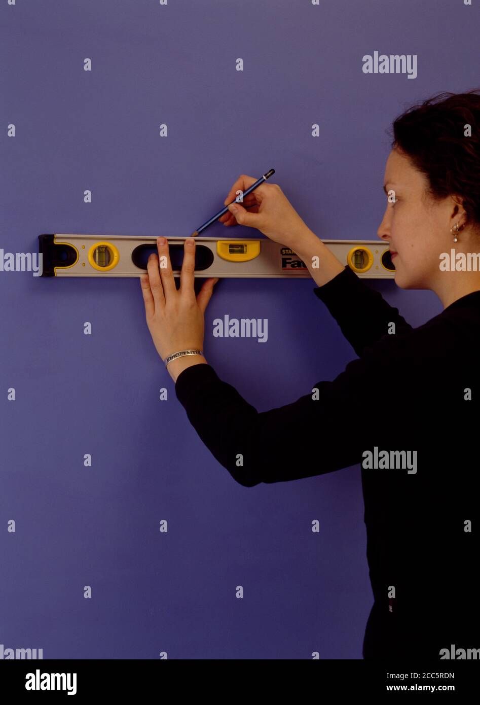 Frau mit gerader Kante zu bekommen gerade Linie zu beginnen Kacheln nach Stockfoto