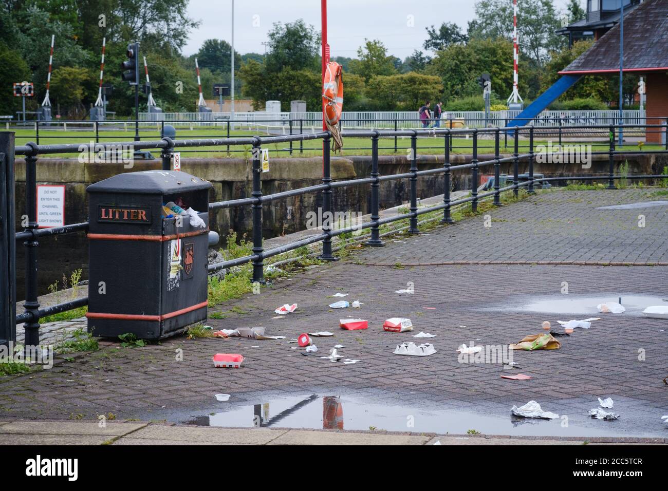 Müll und Abfall rund um einen Wurf-Papierkorb im Preston Docks in Lancashire. Stockfoto