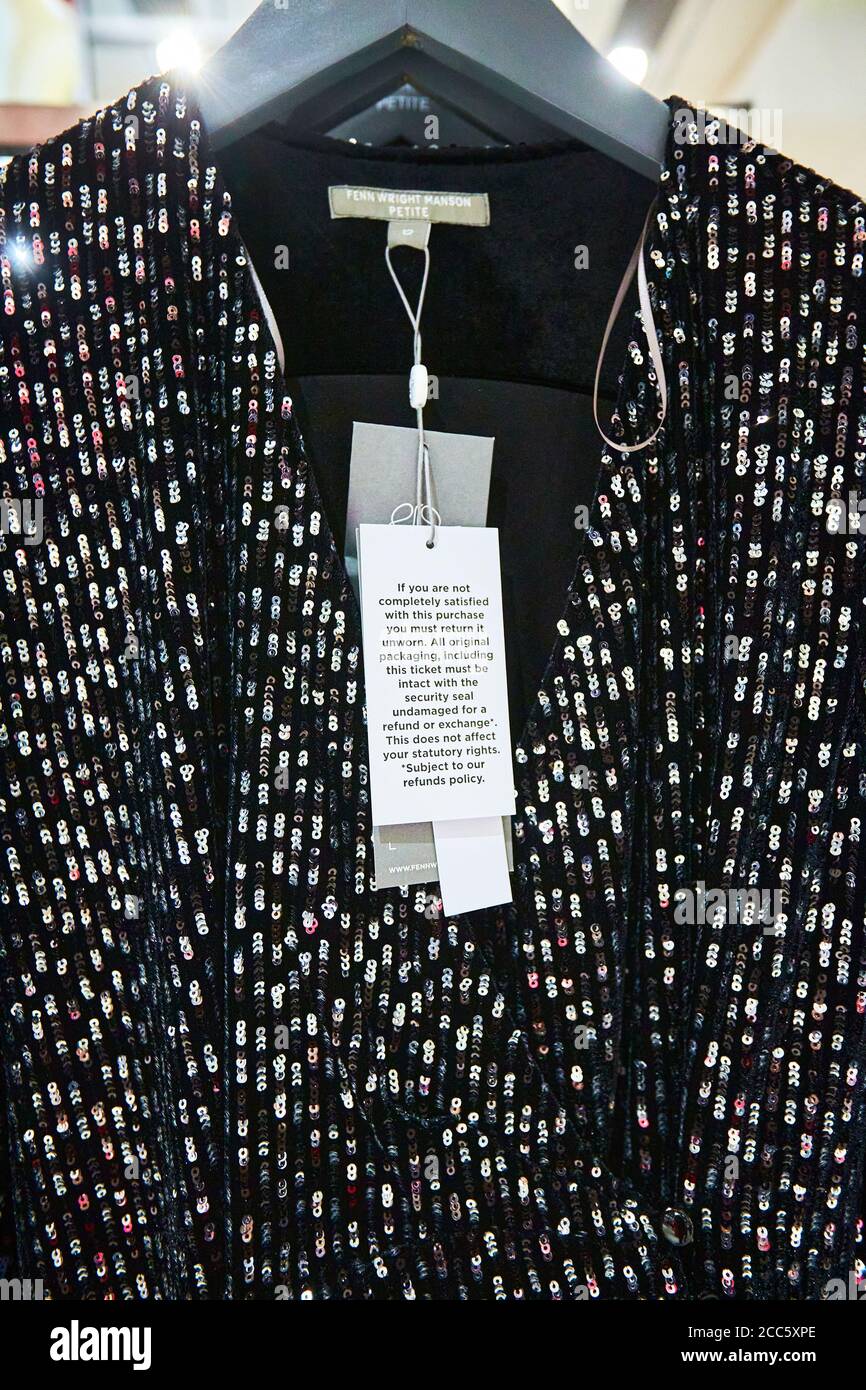 Ein Kleid von Fenn Wright Manson mit einem Etikett, das angibt, dass der Artikel nicht getragen werden muss, um Qualität für eine Rückerstattung. Modehändler kämpfen zunehmend mit hohen Renditen. Stockfoto