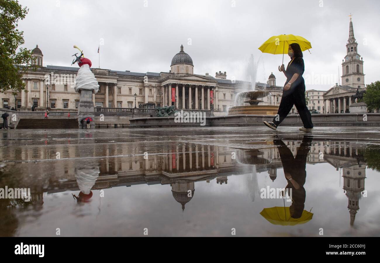 Eine Frau schützt sich vor dem Regen unter einem Regenschirm, während sie durch den Trafalgar Square in London geht, da viele Teile Großbritanniens vor dem Eintreffen des Sturms Ellen, der voraussichtlich starke Winde bringen wird, feuchtes Wetter erleben. Stockfoto