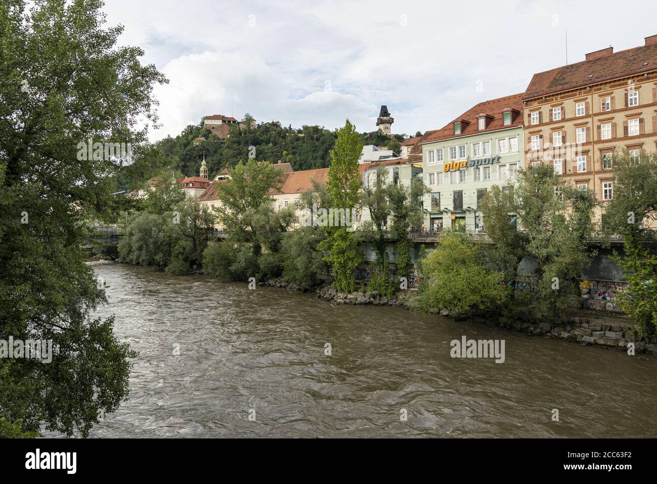 Graz, Österreich. August 2020. Blick auf die Mura mit dem Schloss und dem Uhrenturm im Hintergrund. Stockfoto