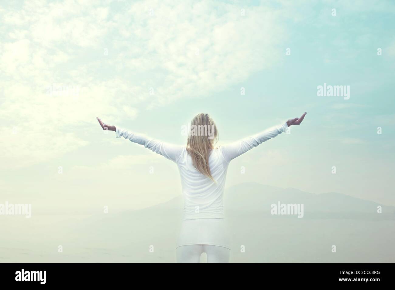 Frau atmet vor blauem Himmel Stockfoto