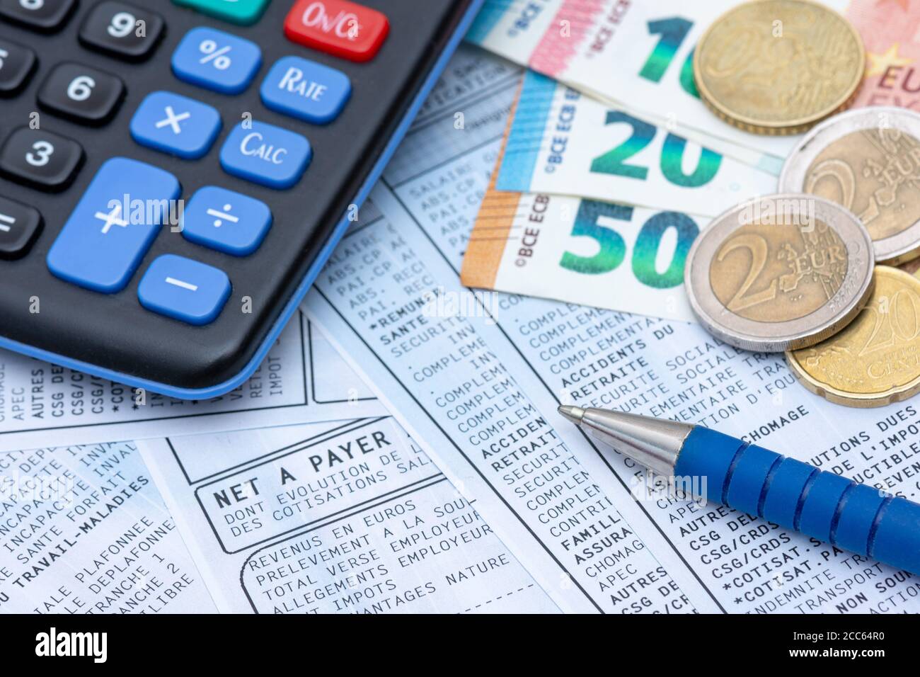 Französische Gehaltsabrechnung mit Sozialabgaben und Einkommensteuerabzug,  zusammen mit einem Rechner, einem Stift und Euro-Münzen Stockfotografie -  Alamy