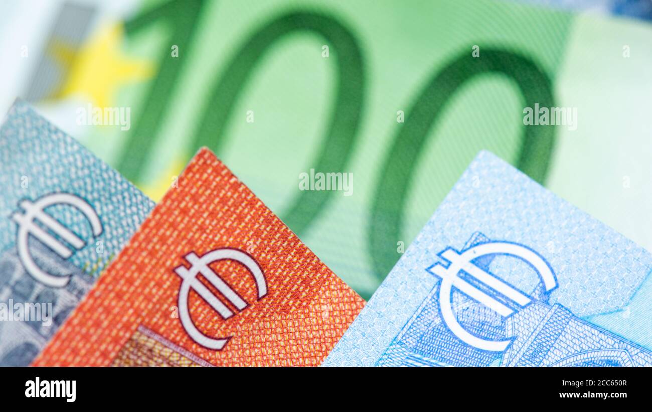 Nahaufnahme der Euro-Symbole auf 5, 10, 20 Euro-Banknoten. 100 Euro grüne Banknote im Hintergrund Stockfoto