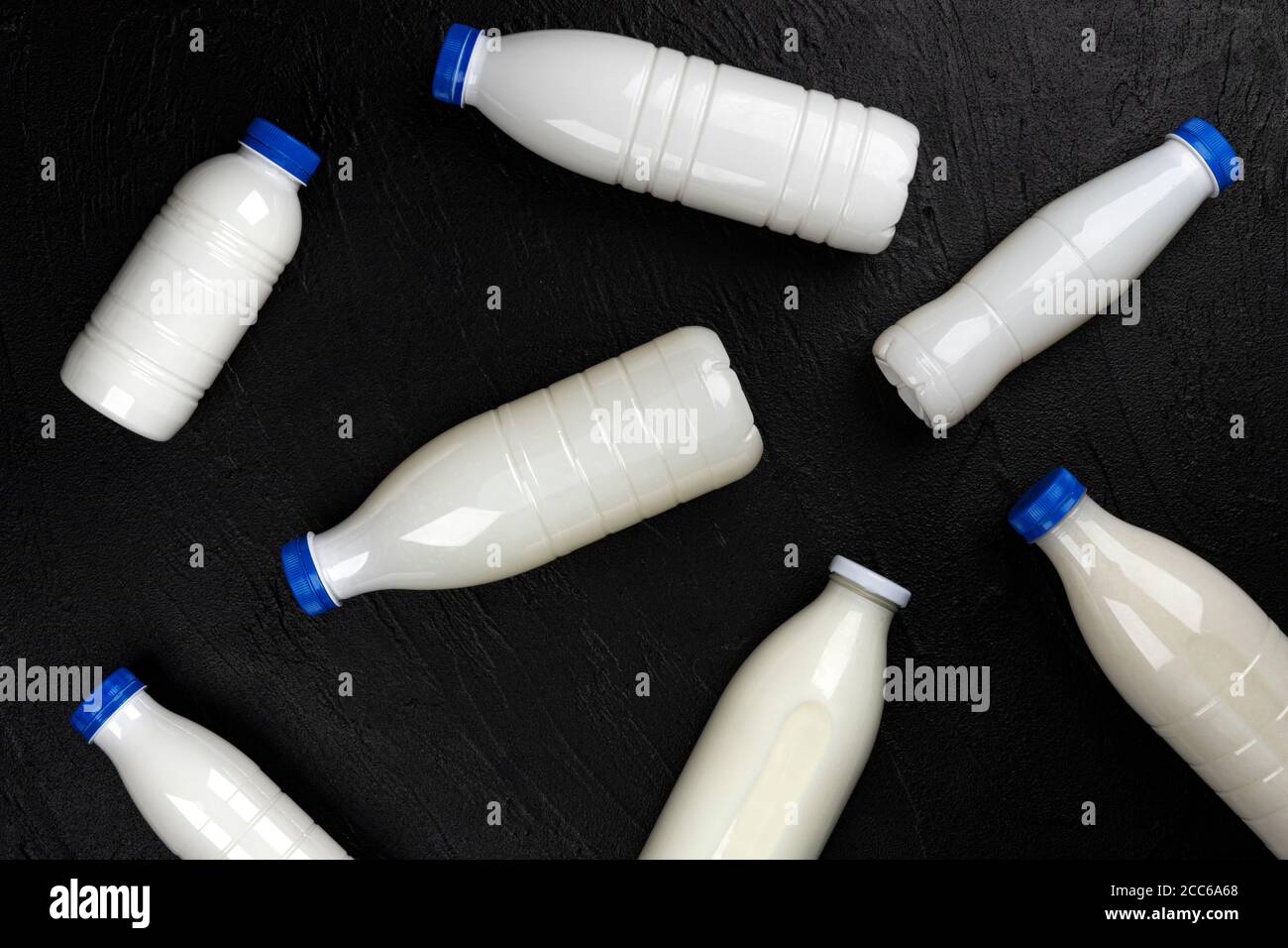 Milchprodukte Verpackung, Flaschen und Gläser mit Milch auf schwarzem Hintergrund, Draufsicht Stockfoto