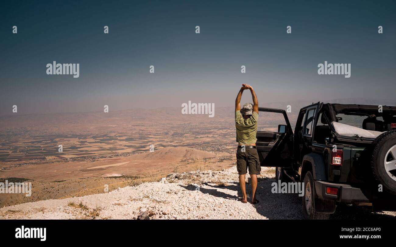 Tourist auf der Pause von einer langen Fahrt. In der Nähe des Autos stehen und sich strecken. Genießen Sie den fantastischen Blick auf das Bekaa-Tal. Aktiver Sommerurlaub. Road Trip. Stockfoto