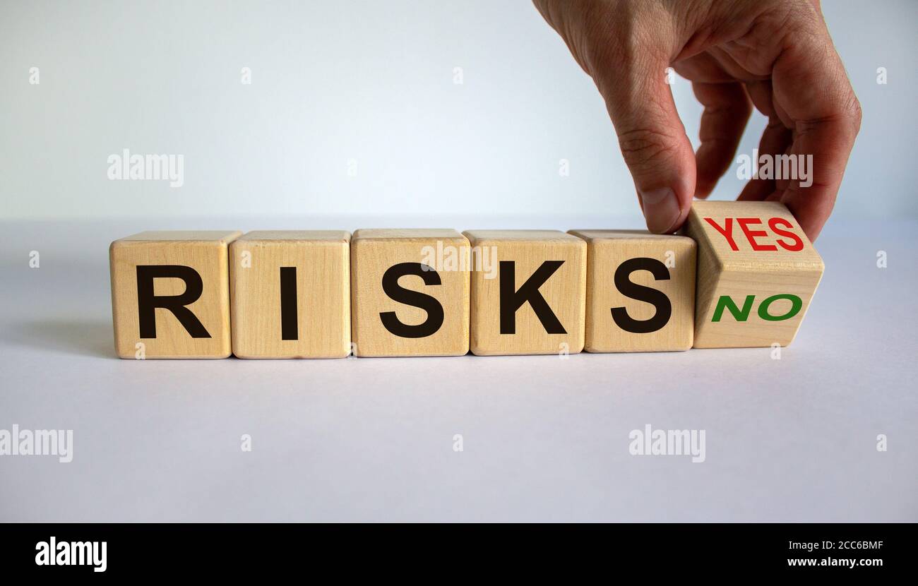 Hand dreht einen Würfel und ändert das Wort 'Nein' in 'Ja' oder umgekehrt. Wort „Risiken“. Schöner weißer Hintergrund, Kopierbereich. Geschäftskonzept. Stockfoto