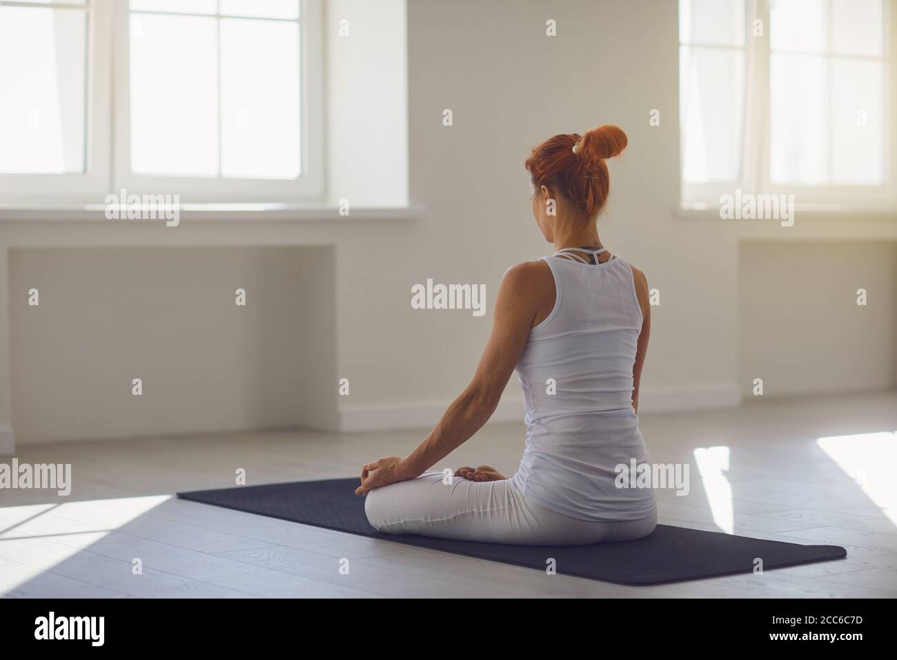 Yoga-Mädchen. Rückansicht. Fitness-Mädchen übt Yoga in lotus-position, die in einem Studio sitzt Stockfoto
