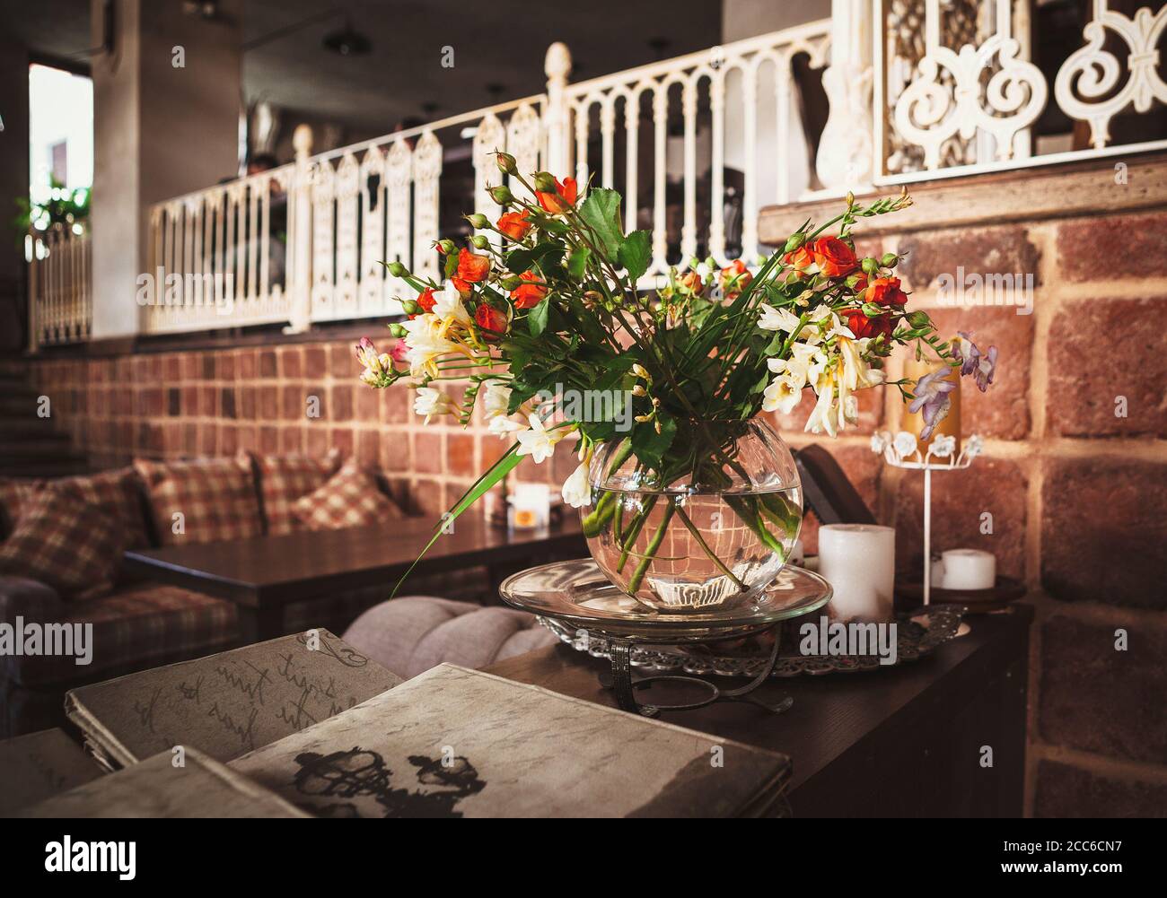 Bouquet mit scharlachroten Rosen im gemütlichen Interieur Stockfoto