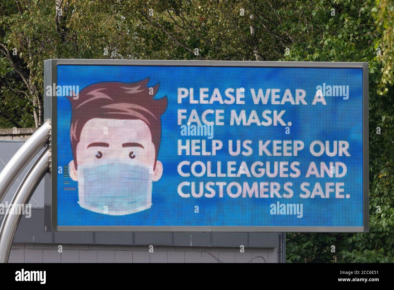 Bitte tragen Sie eine Gesichtsmaske. Helfen Sie uns, unsere Kollegen und Kunden während der Coronavirus-Pandemie, England, bei der Moto Autobahndienststelle zu schützen Stockfoto