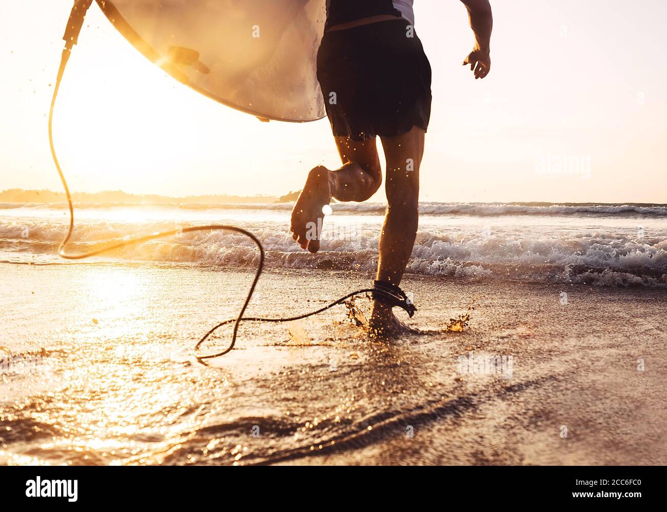 Man Surfer laufen im Meer mit Surfbrett. Aktiver Urlaub, Gesundheit Lifestyle und Sport Konzept Bild Stockfoto