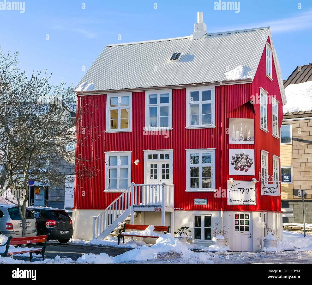 Farbenprächtiges rotes Gebäude aus Wellblech, Kogga Ceramic Gallery & Studio, Rekjavik, Island im Winter bei Sonnenschein Stockfoto