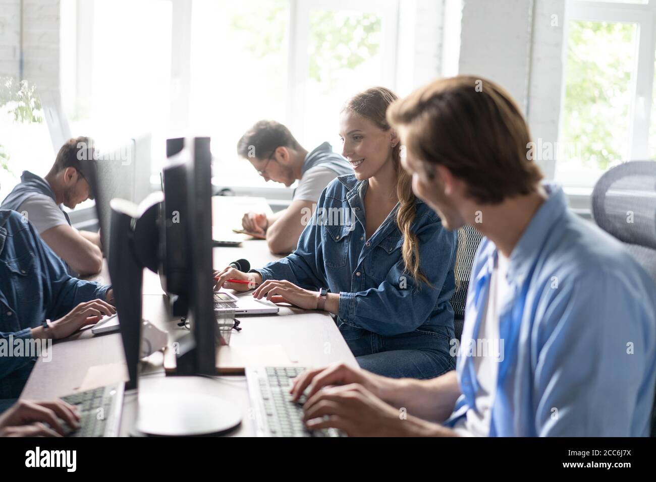 Das Team Arbeitet An Schreibtischen Im Vielbeschäftigten Büro. Stockfoto