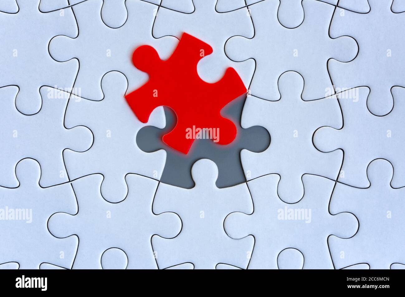 Weiße Puzzle-Stücke auf grauem Hintergrund Stockfoto