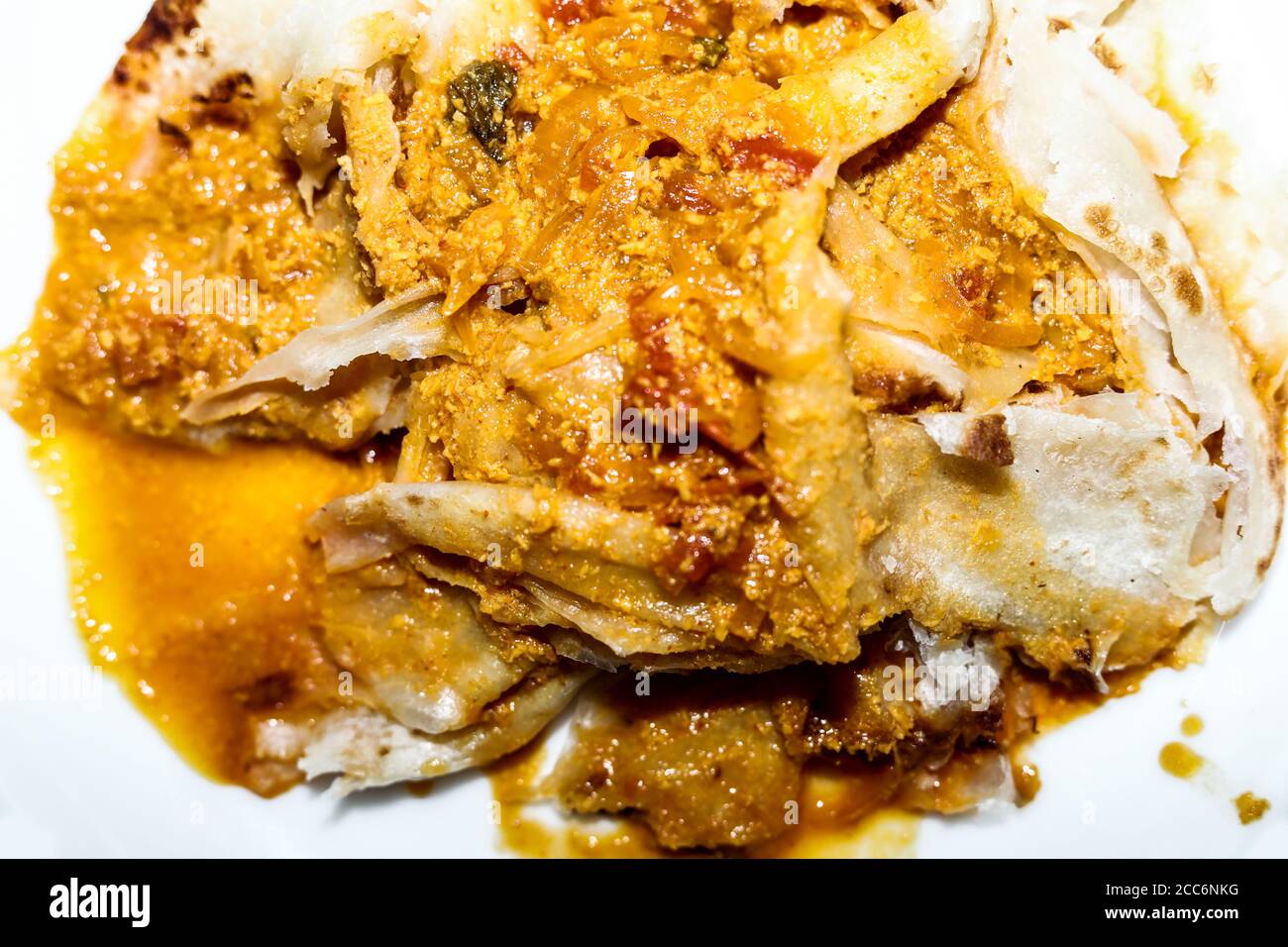 Hausgemachter Weizenparatha oder geschichteter Parotta/Fladenbrot serviert Mit Chicken Curry Stockfoto