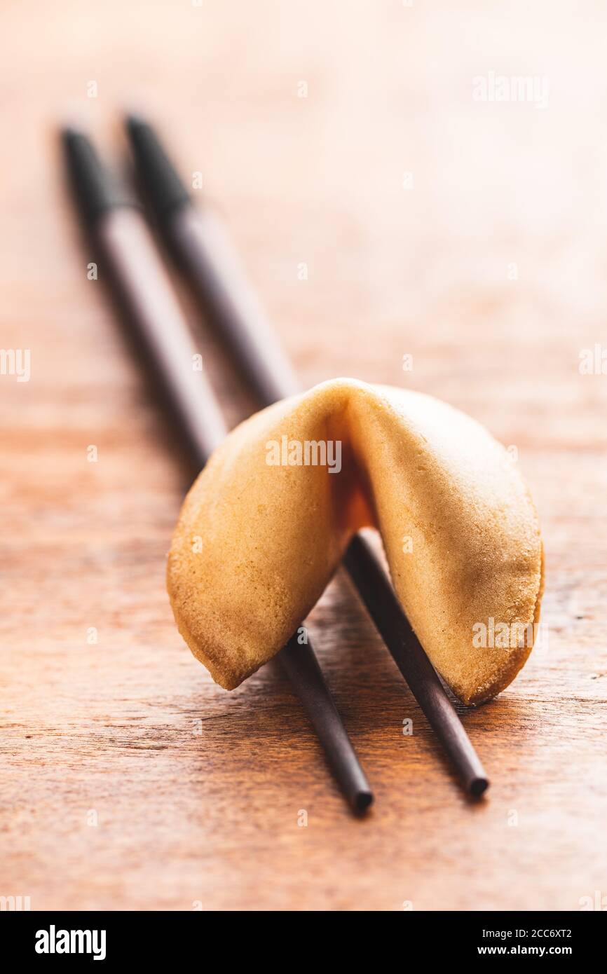 Chinesische Glücksplätzchen. Glücksplätzchen auf Essstäbchen auf Holztisch. Stockfoto