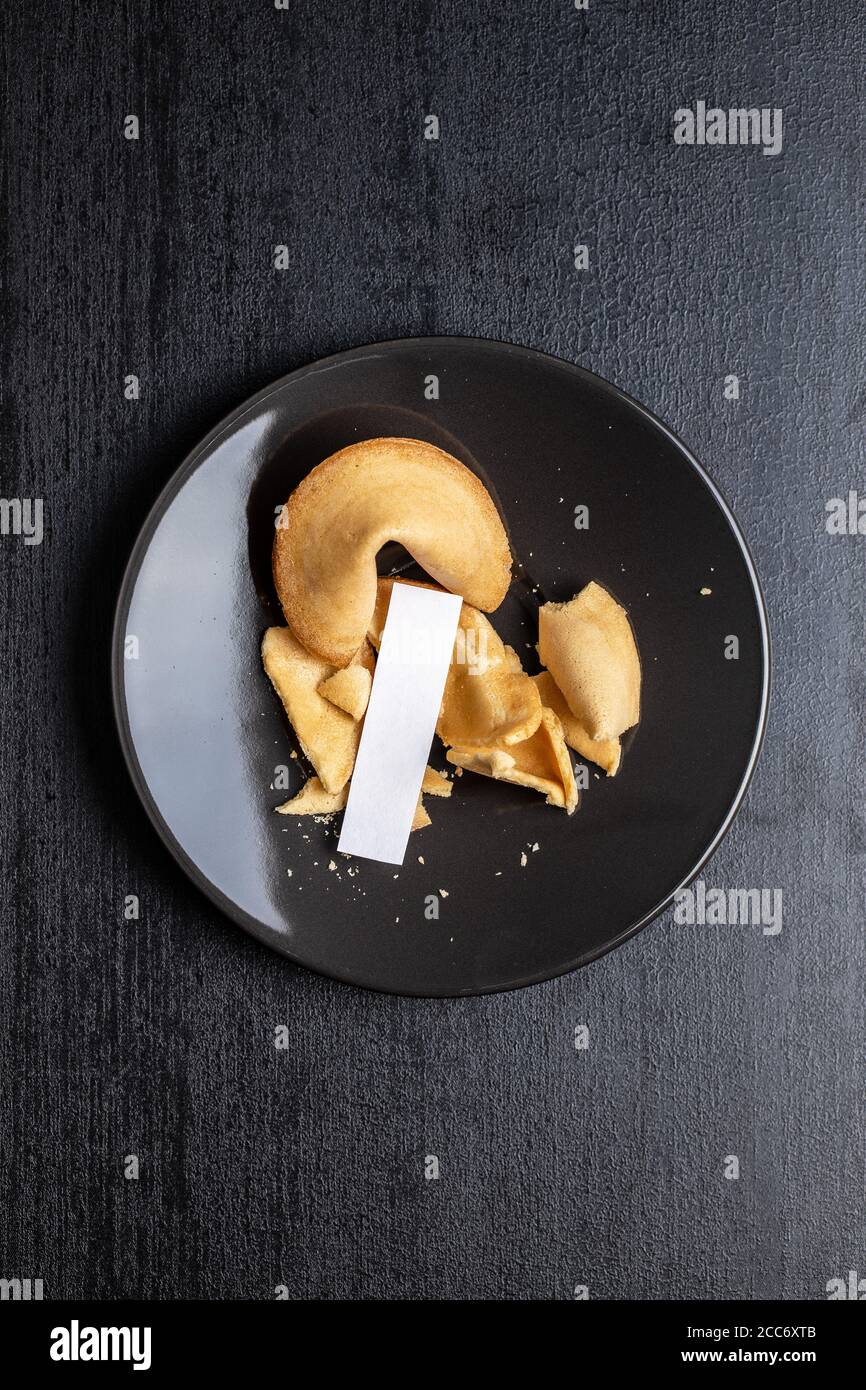 Chinesische Glücksplätzchen. Glücksplätzchen auf schwarzem Teller. Draufsicht. Stockfoto