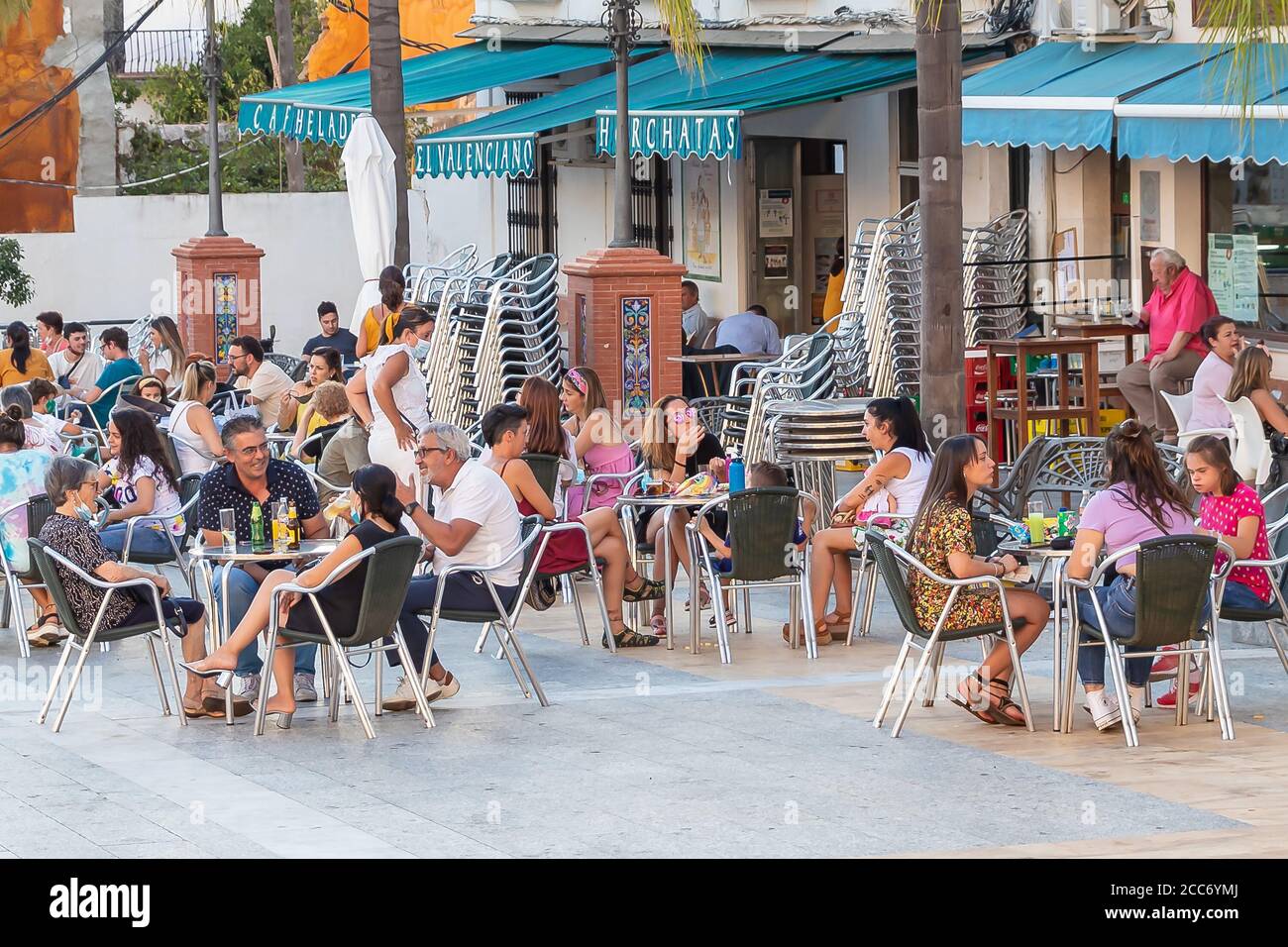 Huelva, Spanien - 17. August 2020: Menschen sitzen auf der Terrasse eines Cafés und Bar das Dorf Valverde del Camino. Die meisten tragen keinen Protecti Stockfoto