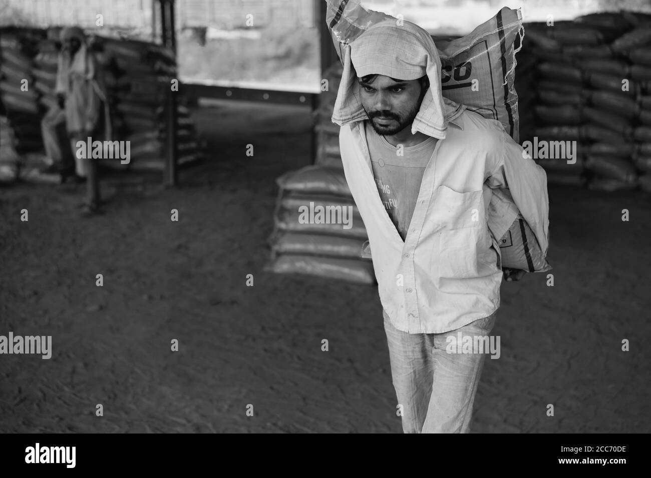 MATHURA, INDIEN - 12. OKTOBER 2019: Der Mann arbeitet am 14. Oktober 2019 in Mat, um den Zementsack bei staubigen Bedingungen aus dem Zug zu entladen Stockfoto