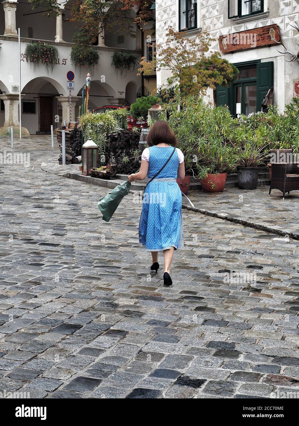 GUMPOLDSKIRCHEN, ÖSTERREICH - 09/01/2018. Kaukasische Frau in typisch blauem österreichischem Kostüm zu Fuß auf der Straße. Stockfoto