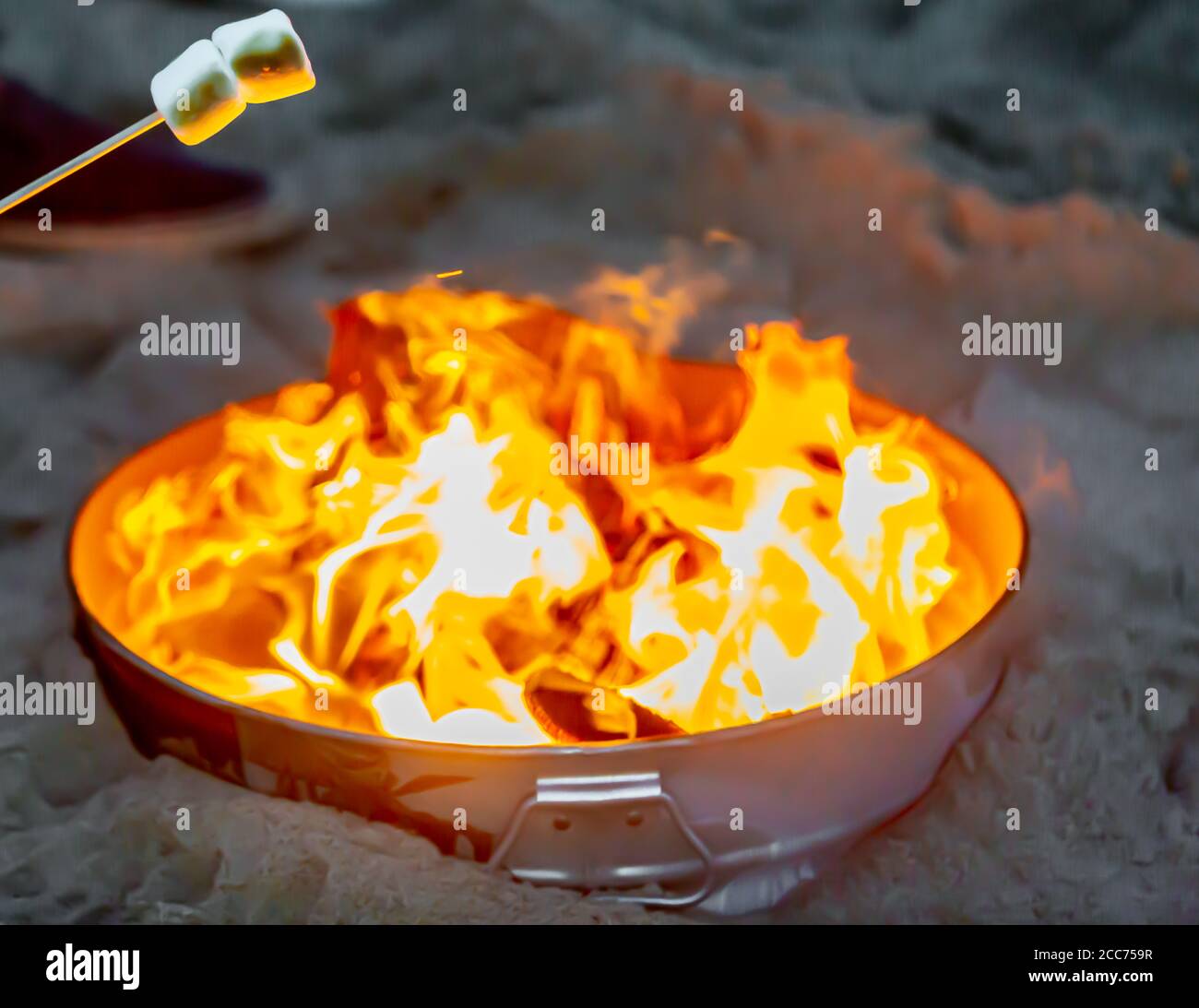 marsh mellows auf einem Stock über einem kleinen Feuer am Strand in Montauk, NY Stockfoto