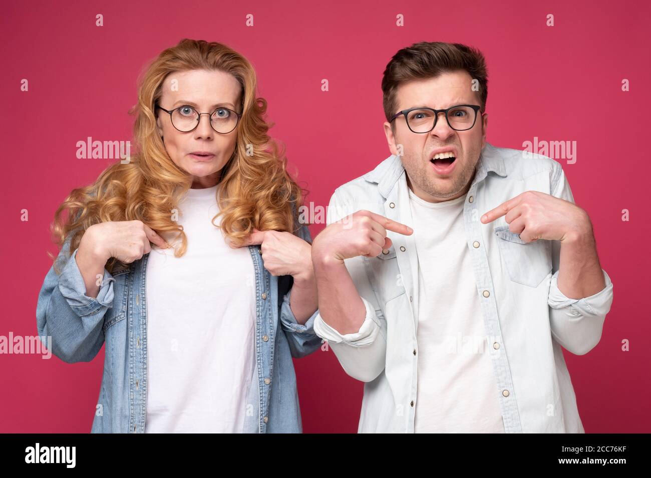 Mann und Frau zeigen mit den Fingern auf sich selbst und haben zweifelhaften Gesichtsausdruck Stockfoto